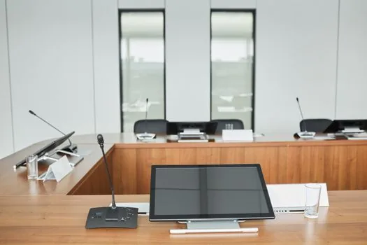 Korean city council chamber with empty seats, agenda papers, microphone and subdued morning light, realistic editorial photo, no readable personal names | 광명시의회 정례회와 징계 절차를 설명하는 중립 행정 뉴스 장면