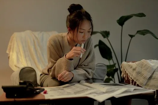 Korean family member calling medical dispute mediation counseling center with hospital documents on table, calm daylight realistic photo | 상담 전 쟁점과 날짜를 메모하는 장면