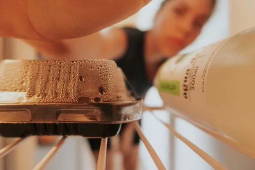 Korean person checking use-by date label on sealed tofu and ham packages inside refrigerator, realistic bright kitchen photo, no brand logos | 냉장고 안 식품 라벨의 소비기한과 보관방법을 함께 확인하는 장면