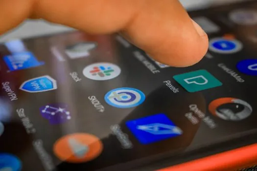 Korean person comparing smartphone notification settings with KakaoTalk Naver app and SMS icons blurred, clean desk, realistic editorial photography, no readable text
