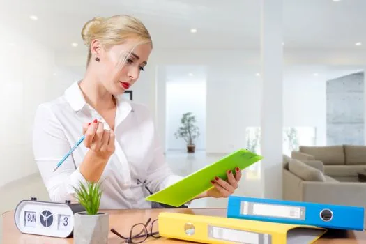 Korean renter checking community center counter ticket and lease folder before submitting resident household certificate request, bright public office scene, no faces | 주민센터 접수 전 번호표와 신청서류를 확인하는 장면