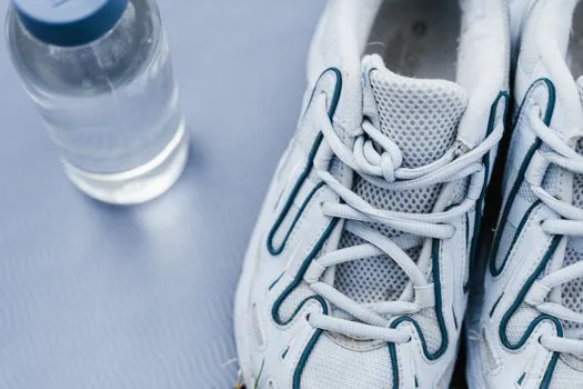 Korean smartphone showing pedometer connection with walking shoes and water bottle on bright floor realistic photo | 걸음 수 보수계 연동과 건강 걷기 준비를 확인하는 장면