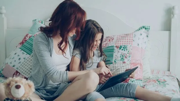 parent comparing postpartum care provider list and voucher cost table on tablet | 산후도우미 제공기관과 본인부담금 비교 장면