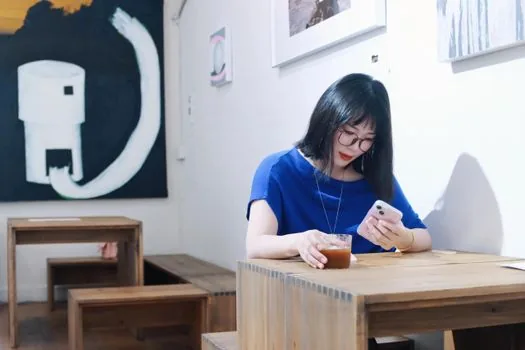realistic Korean cafe table with smart glasses wearer and bystander noticing small recording light, privacy concern documentary photo | 카페에서 스마트안경 촬영 여부를 의식하는 장면