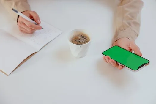 Korean fan searching variety show clips on smartphone with notes reading episode date and keywords, bright desk with headphones, no logos | 전참시 타잔 클립 검색어를 정리하는 장면