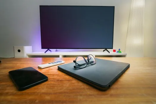 Korean viewer checking MBC variety episode list on smartphone while TV remote rests nearby, realistic living room evening light, no logos | 전참시 418회 방송 날짜와 다시보기 항목을 확인하는 장면